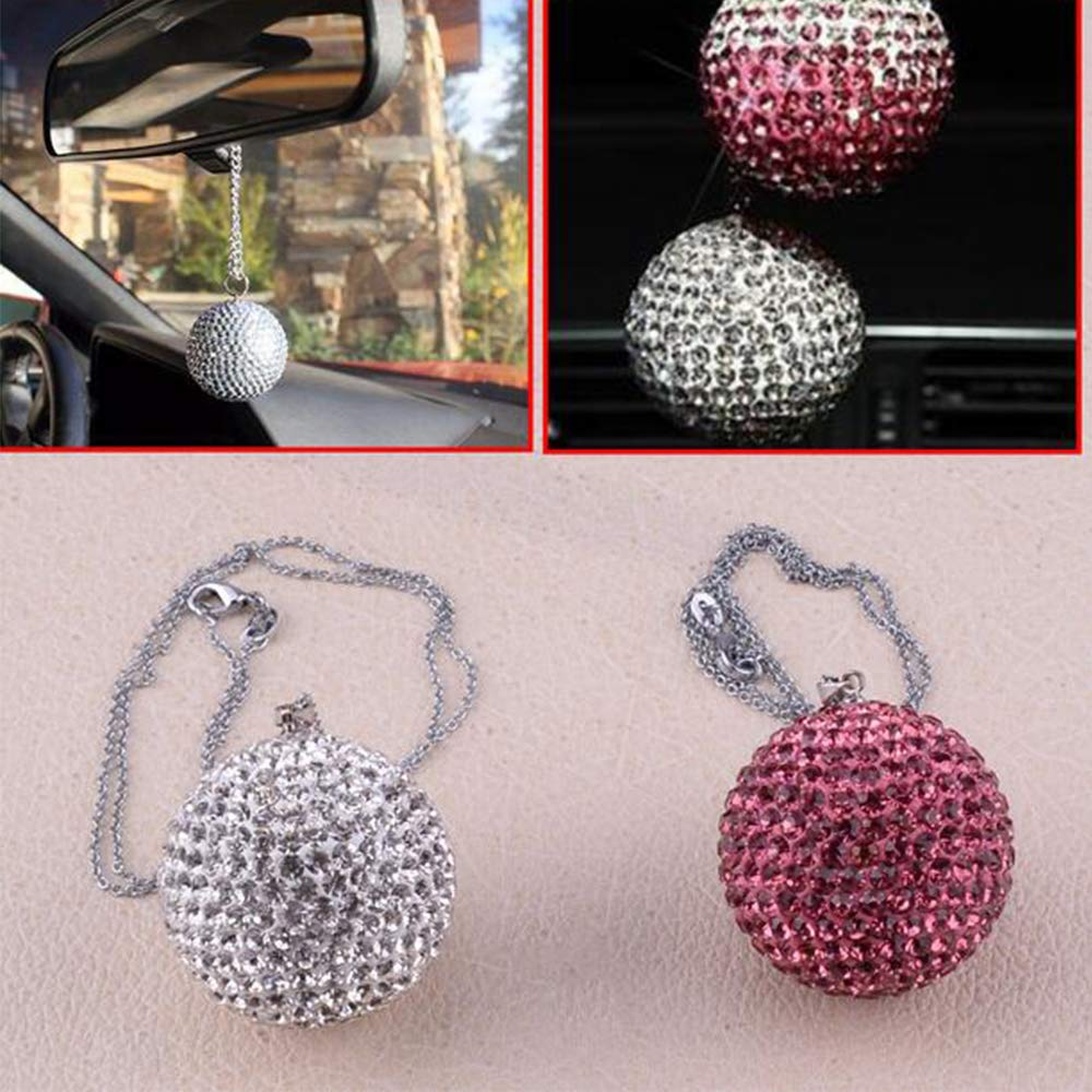 Decoratieve kristallen auto-ornamenten in wit en roze/rood, bedoeld om aan de binnenspiegel te hangen.